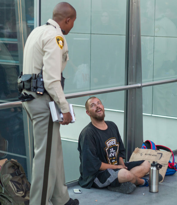 A NASCTEC security person talking to a homeless person